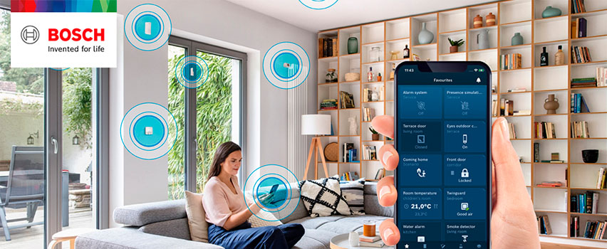 Bosch Smart Home app toont favorieten zoals alarm, deuren, kamertemperatuur en rookmelder in smart home met vrouw op bank