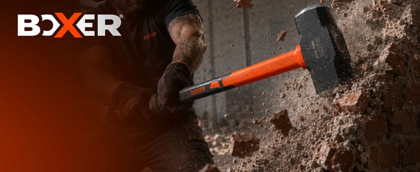 Boxer voorhamer met oranje steel – vakman breekt betonnen muur met zwaar Boxer sloopgereedschap