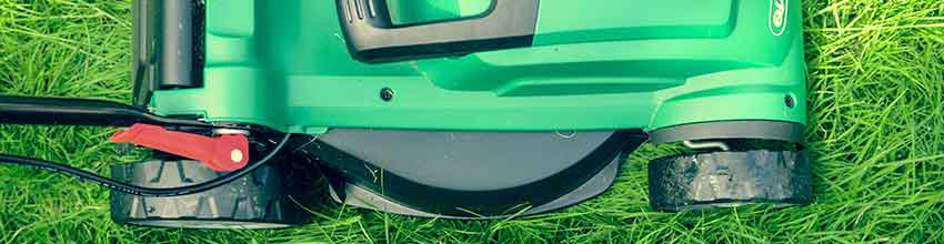De helft van een groene grasmaaier is te zien bovenop een mooi groen gazon.