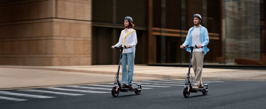 Twee personen rijden naast elkaar op Navee GT5 Max e-steps in de stad – ideaal voor dagelijks woon-werkverkeer