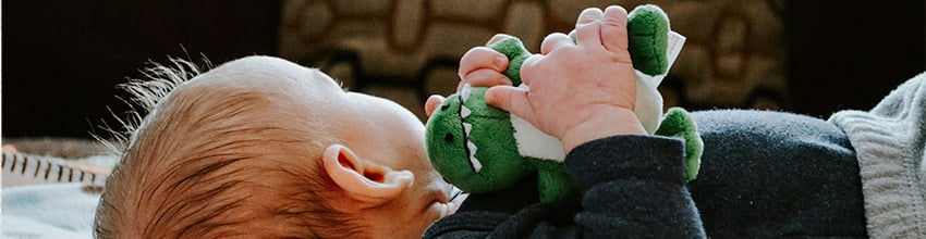 Babyjongen met knuffeldier in zijn handen, cadeau-idee voor jongens dat uitnodigt tot spelen en geborgenheid.