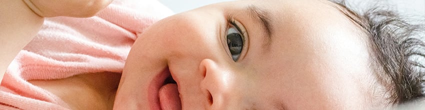 Lachende babymeisje in het roze, cadeau-idee voor meisjes dat vreugde en verbondenheid creëert.